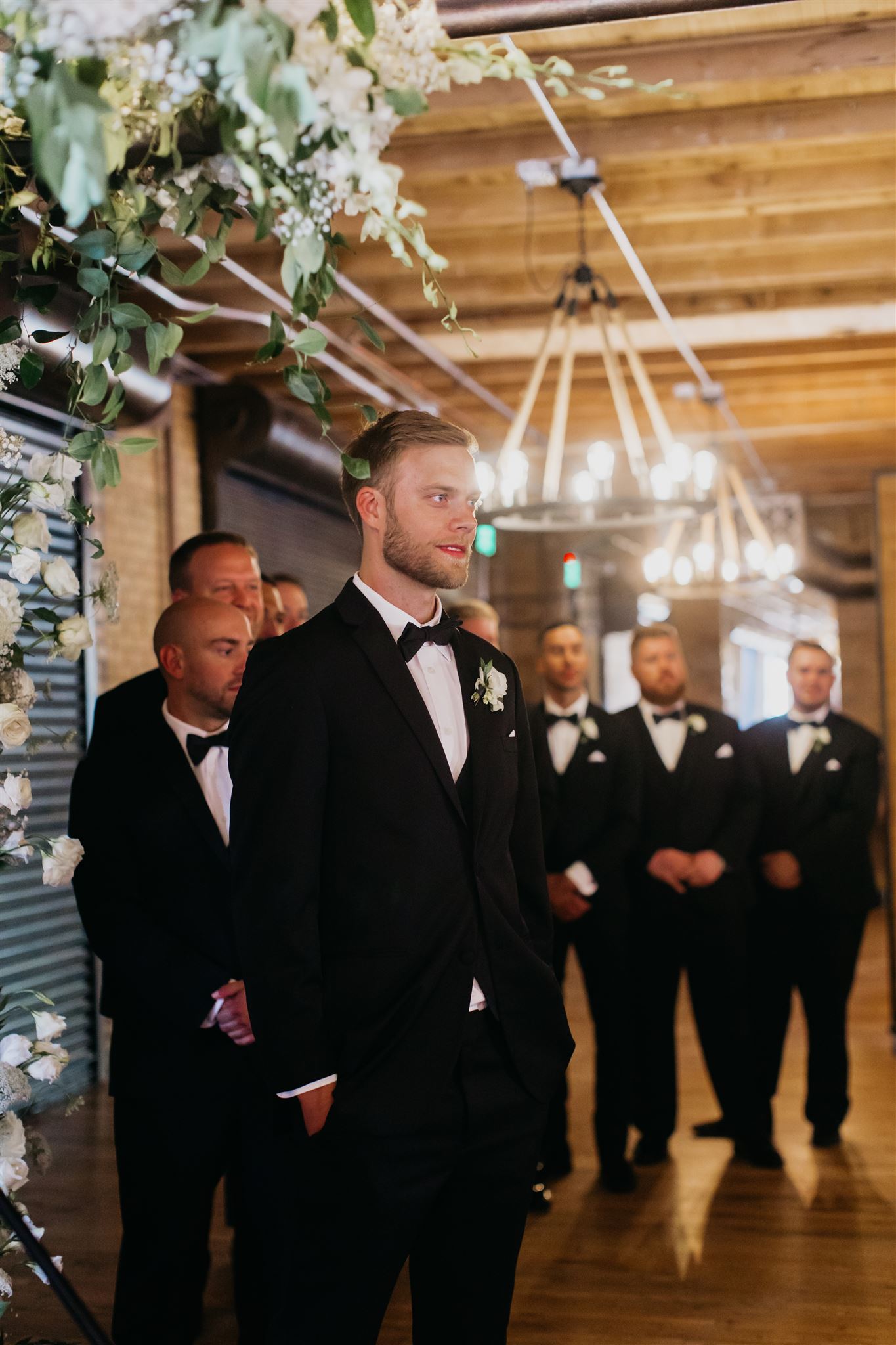 A groom watching her future spouse as she makes her way down the wedding aisle