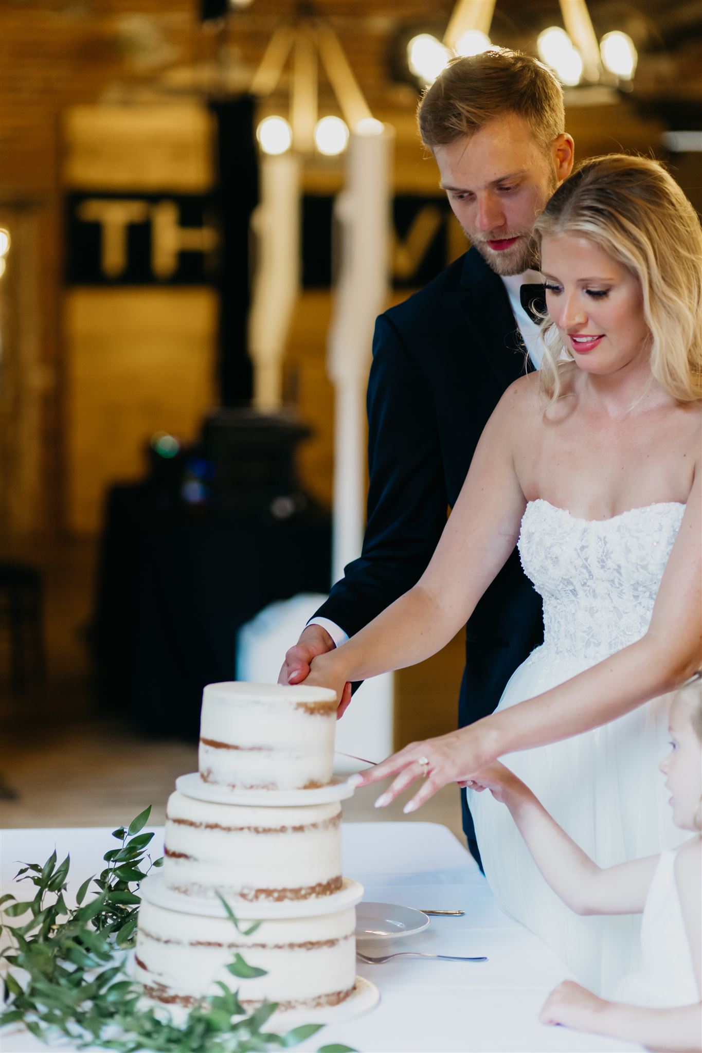 The bride and groom slicing the cake together as husband and wife