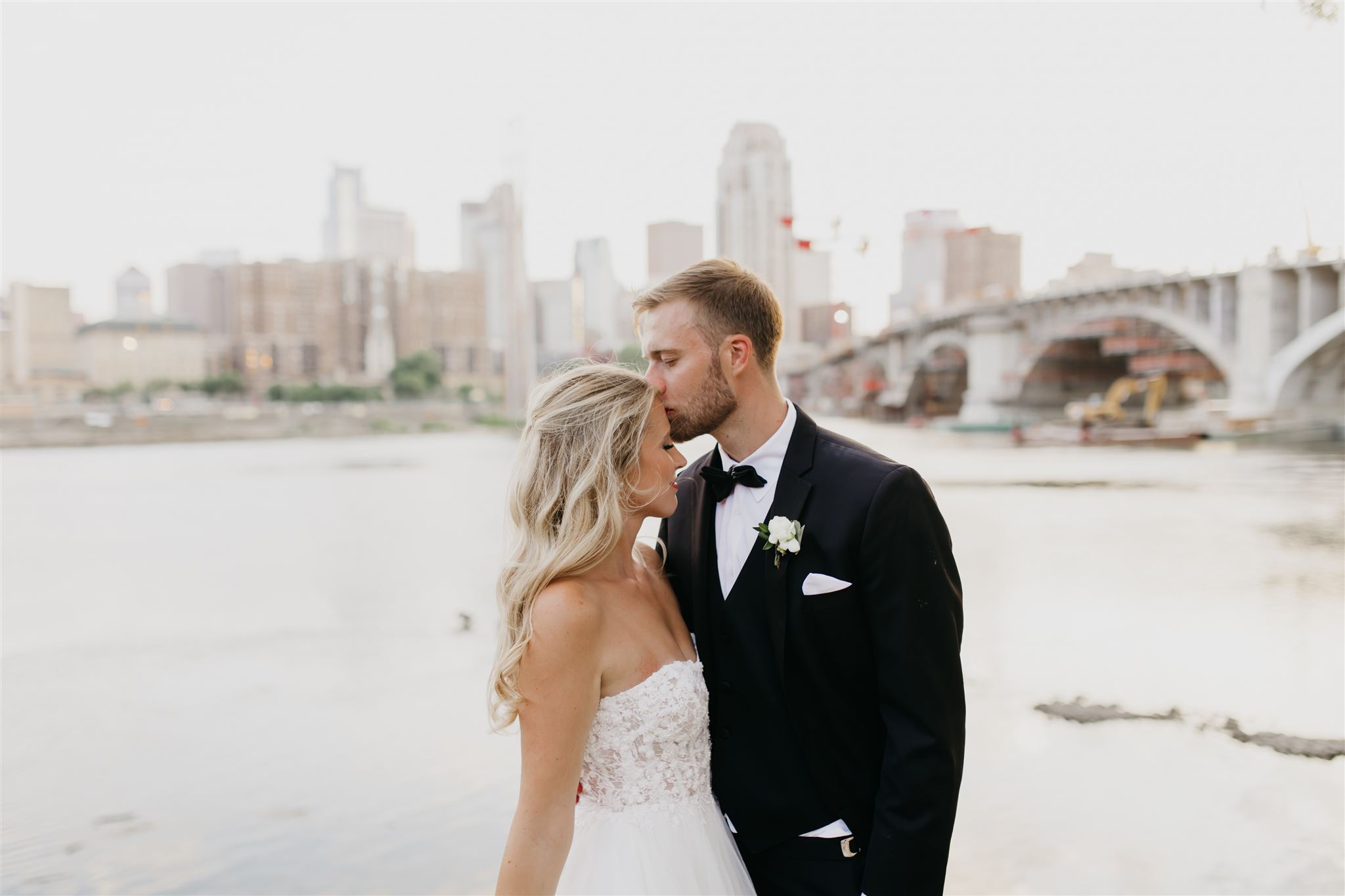 A lovely photo of the groom kissing the bride's forehead outside the views of Minneapolis Event Center