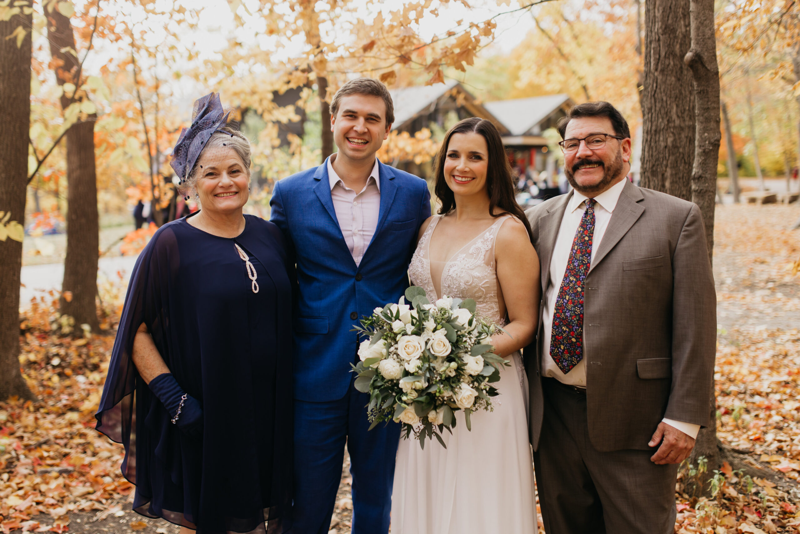a photo of the bride and groom with their loved ones during their fall wedding