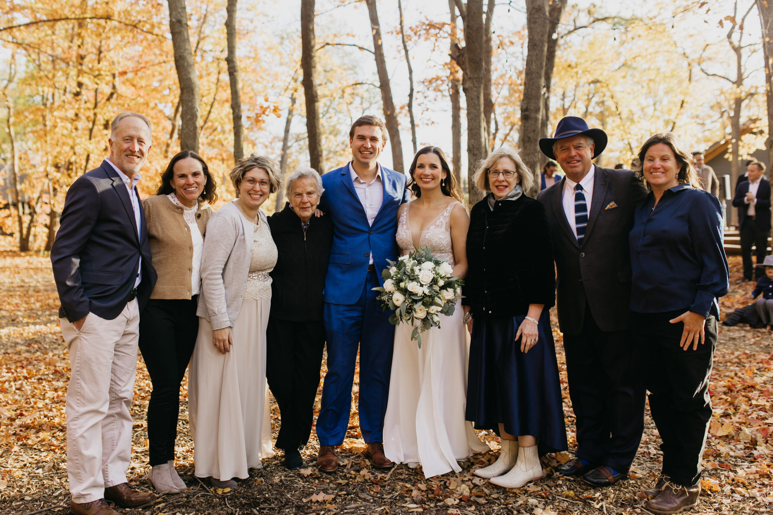 a photo of the bride and groom with their loved ones during their fall wedding