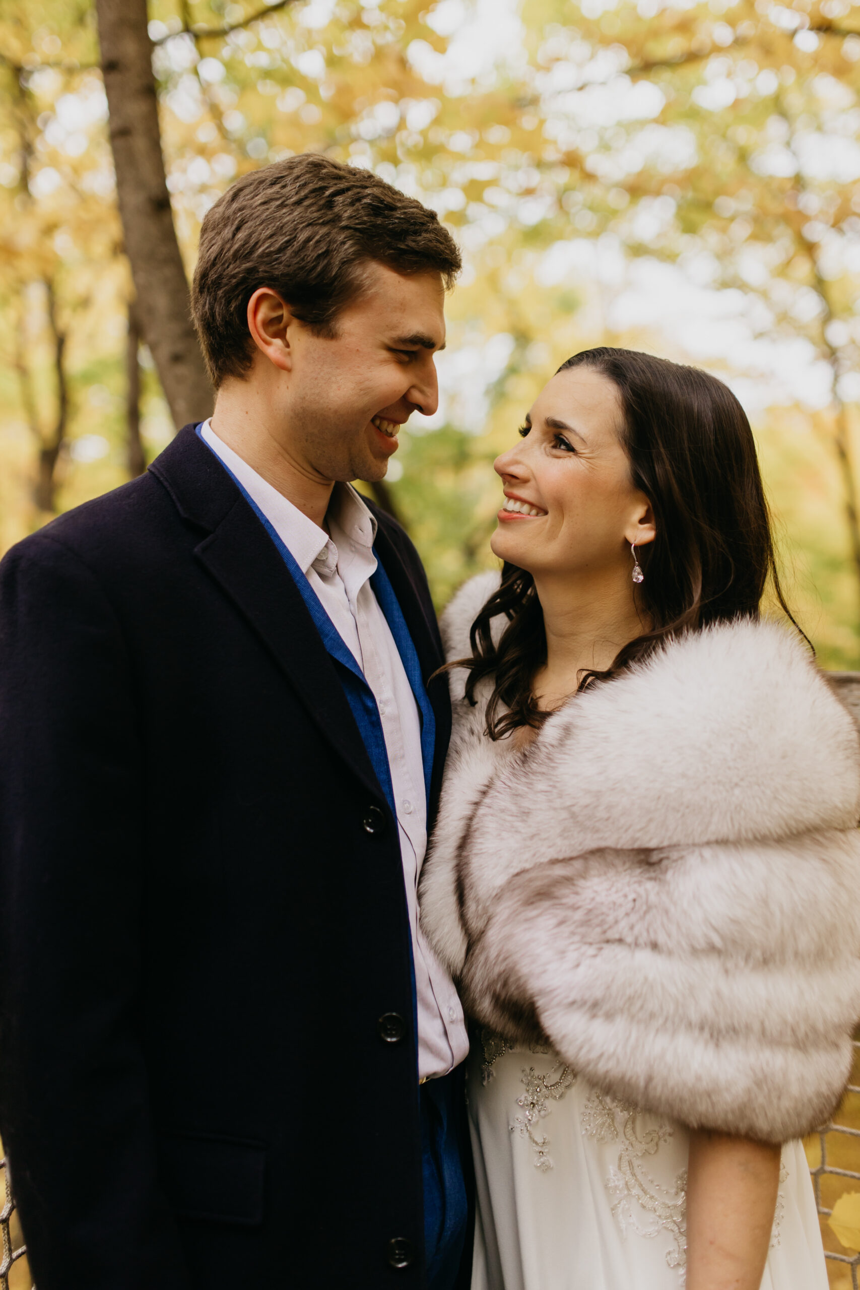 A lovely couple lovingly glances at each other in a fall shoot