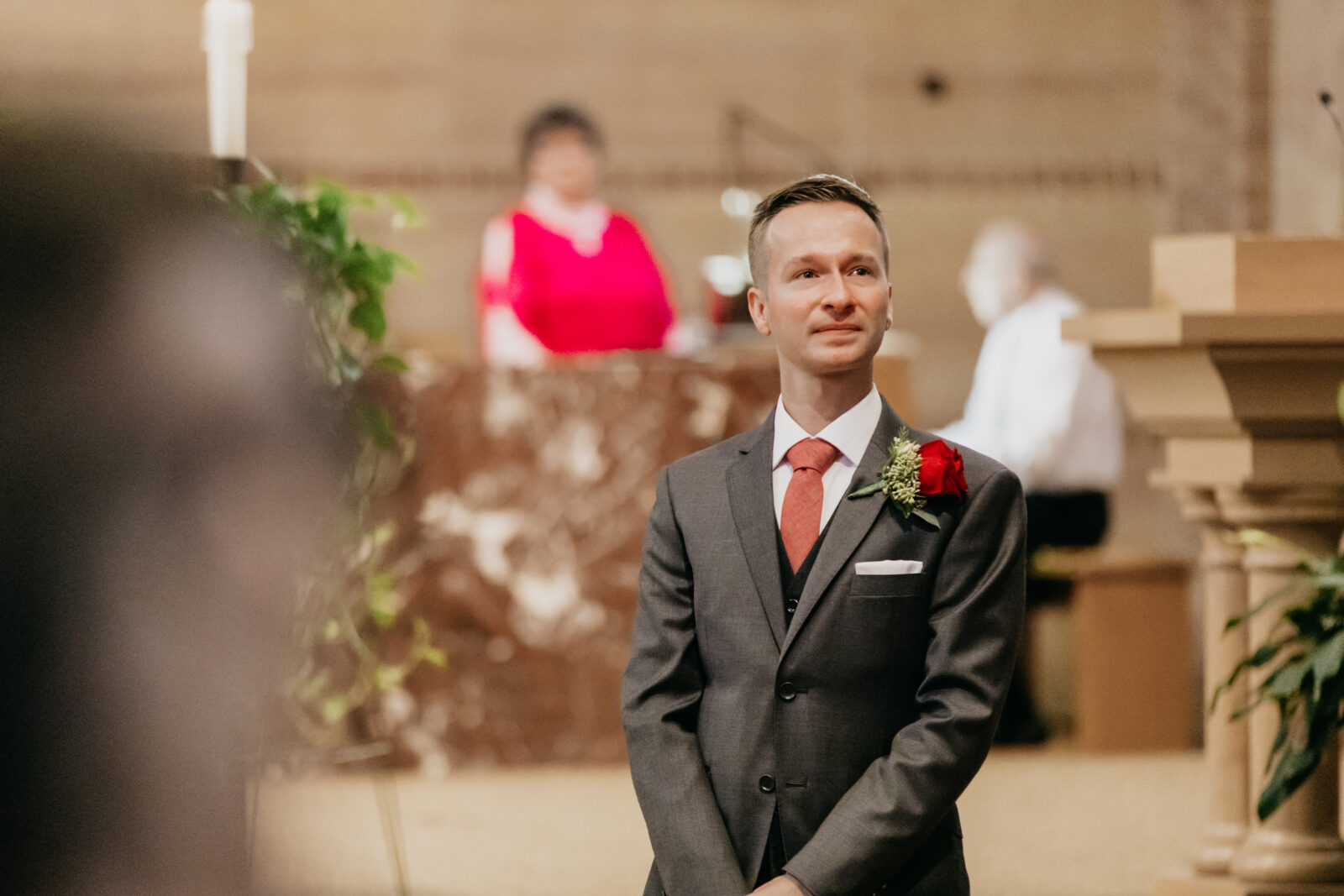 Photo of the groom being emotional looking at his soon-to-be wife being walked down the aisle with her father 