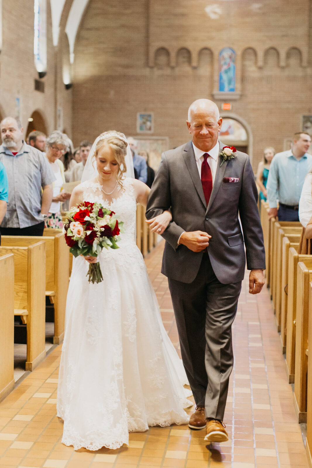 Photo of the bride being walked down the aisle with her father during her wedding day