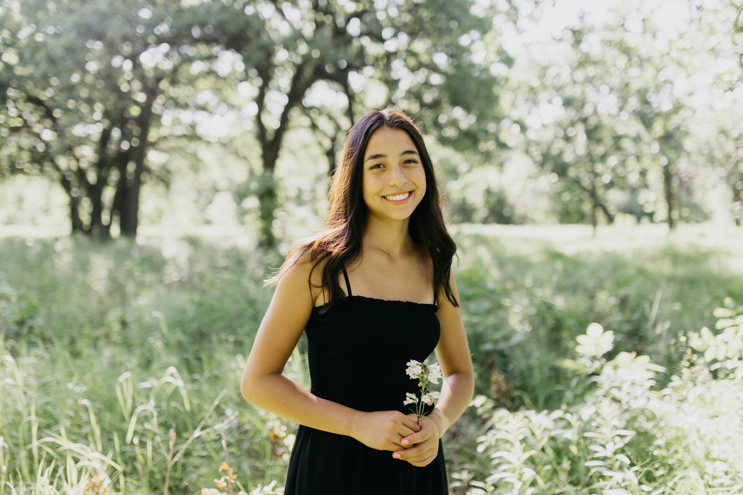 A photo of a High School Senior wearing her lovely black dress with the nature as the background