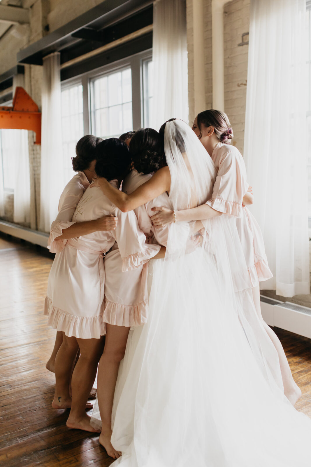 A lovely photo of the bride and her bridesmaids hugging each other