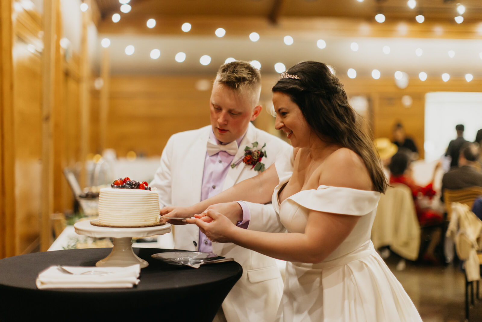 A photo of the bride and groom during their slicing of the cake