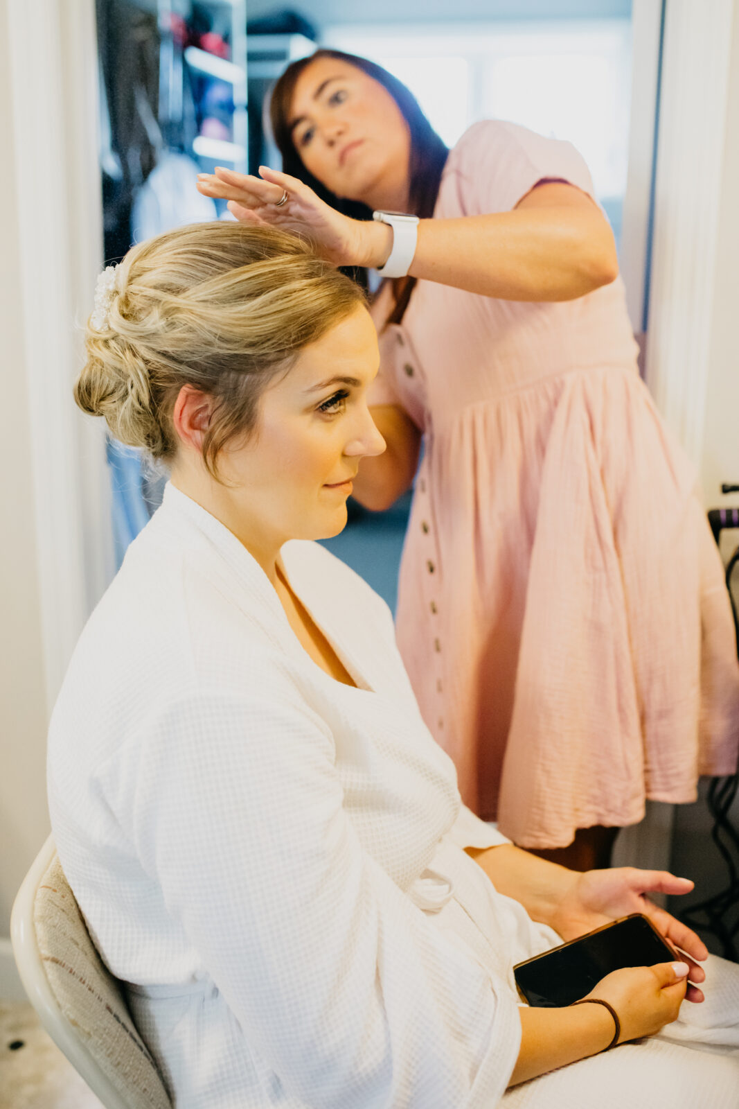 A photo of the bride with her hair stylist during the preparation of her wedding day
