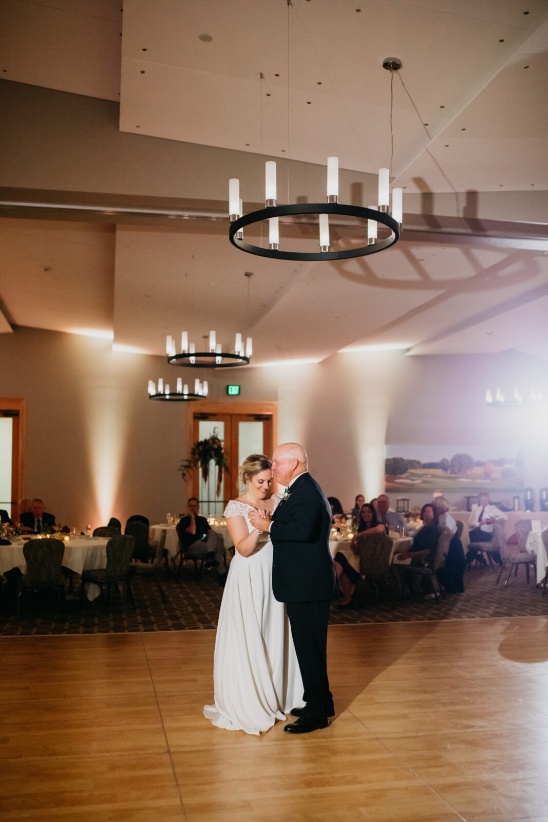 A photo of the bride and her father dancing during her wedding day at the reception
