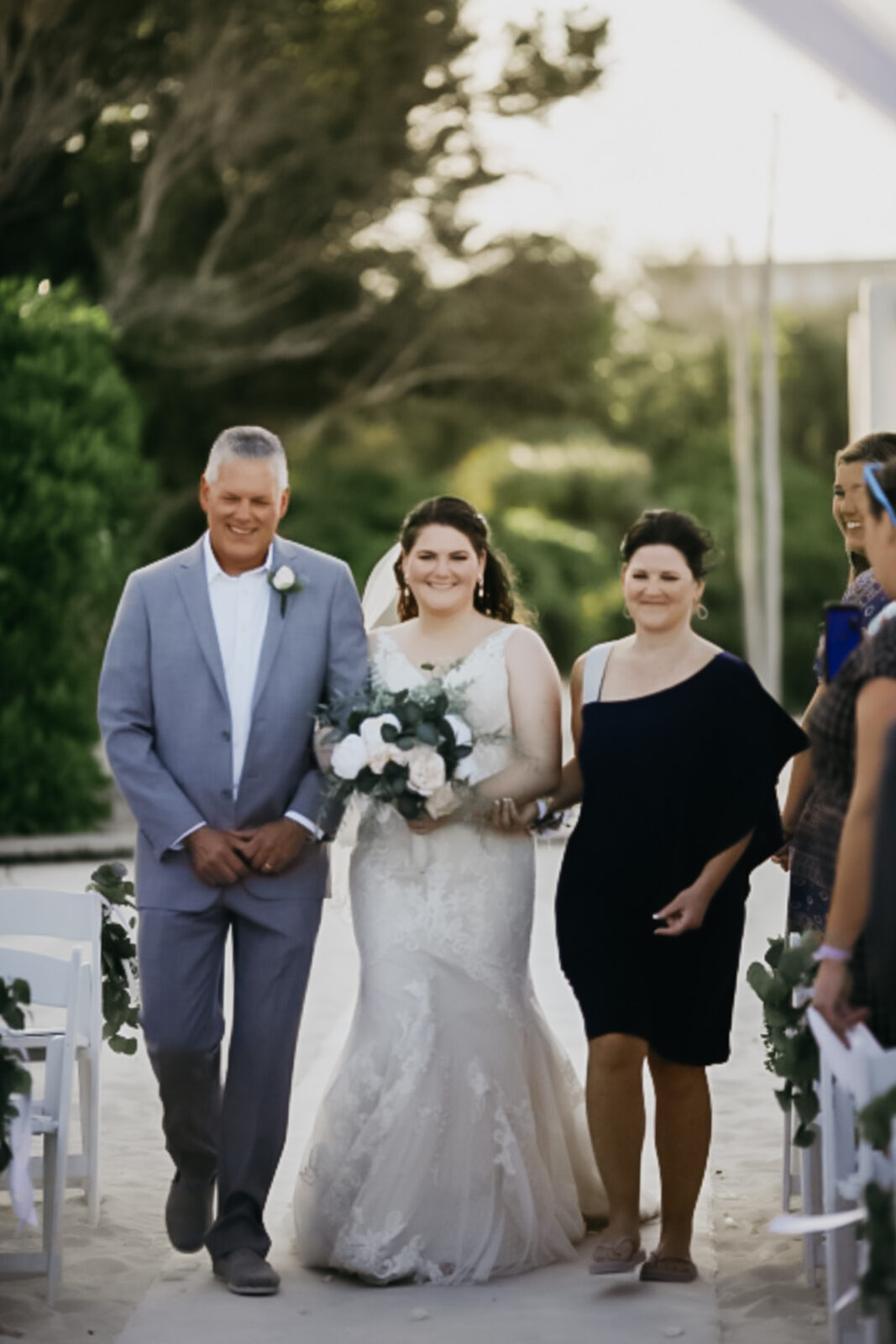 Photo of the bride walking down the aisle with her parents