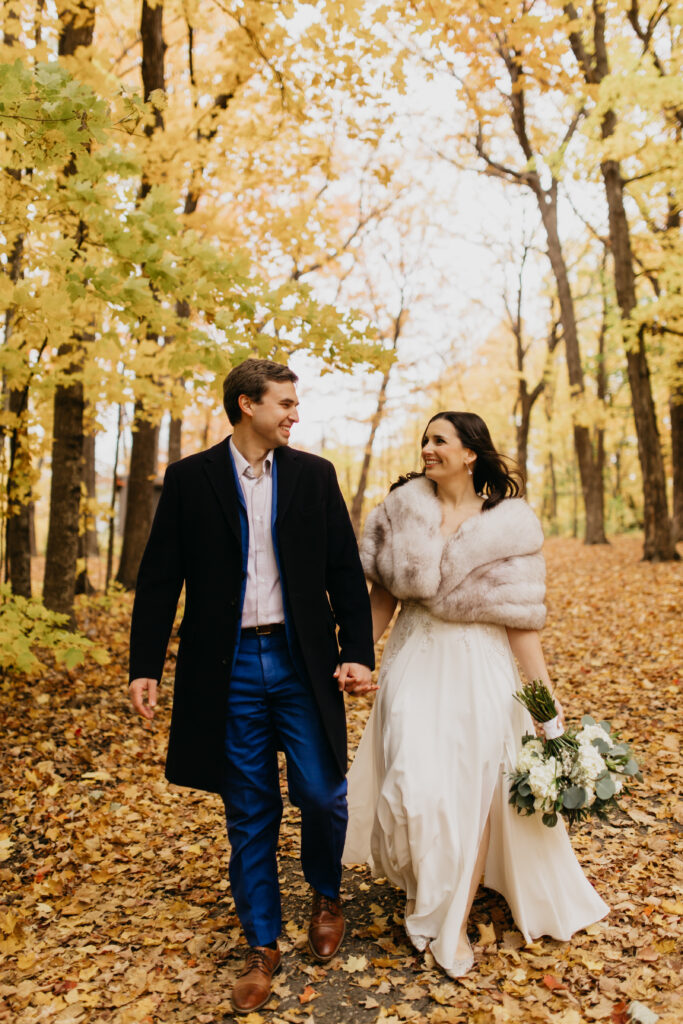 A lovely couple lovingly glances at each other in a fall shoot