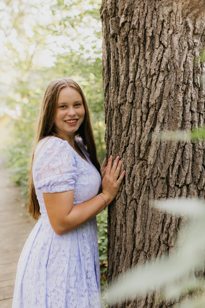 photo of a hopkins high school senior on her blue dress beside a tree
