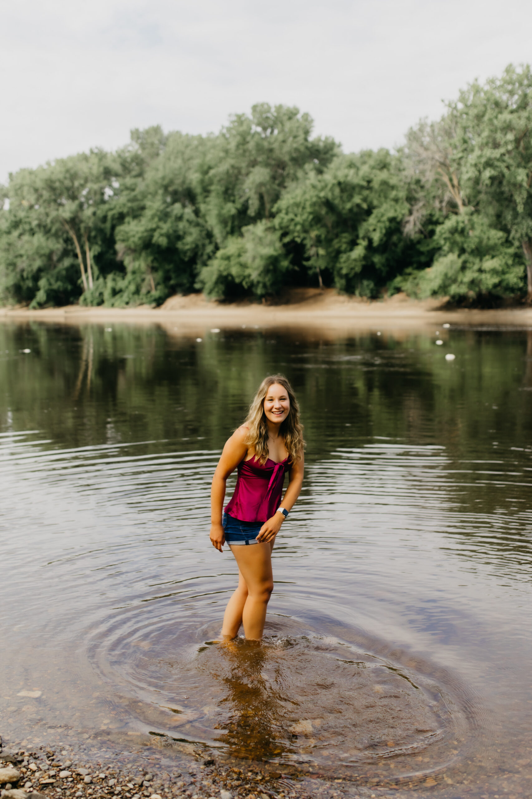 Photo of a Visitation School senior at the lake with her purple top