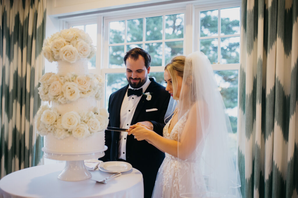 Photo of the groom and bride slicing their cake on their wedding day