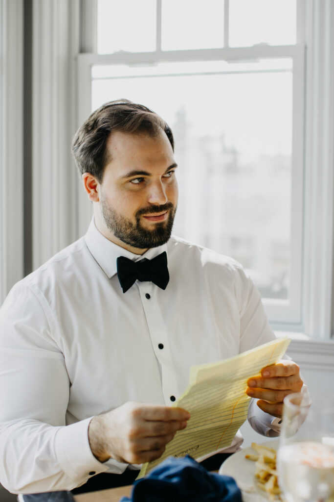 A photo of the groom reading the letter written by his bride during their wedding day