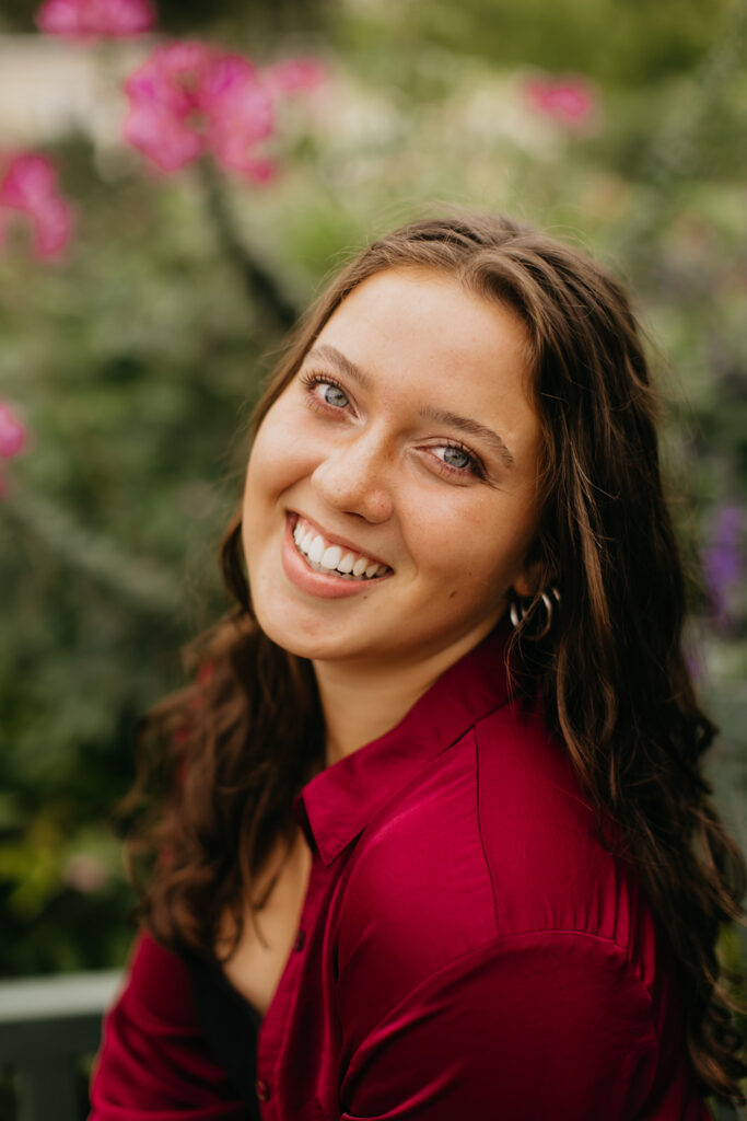 A photo of a senior with flowers as her background