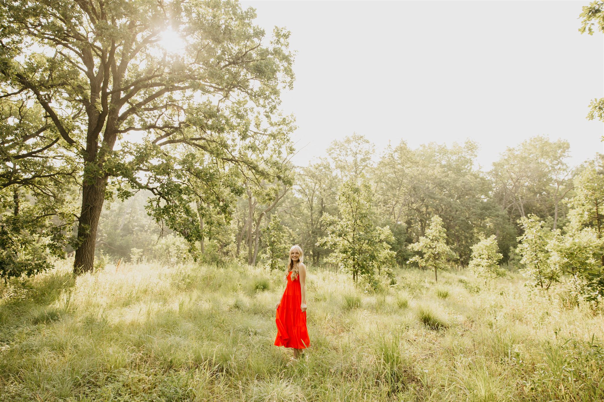 a photo of a senior wearing a flowy radiant dress on a field