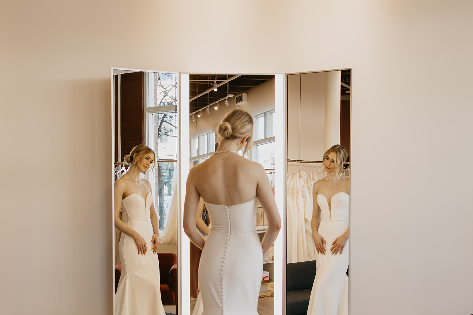 Bride trying on a strapless fitted gown at Vow’d Weddings boutique in Minneapolis, captured by Mycah Bain Photography during a brand photoshoot.