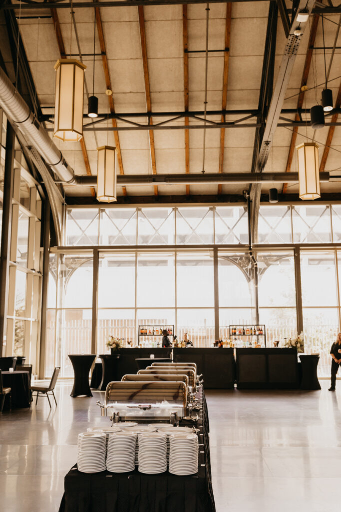 Wedding buffet setup with neatly arranged plates and bar service at Renaissance Depot reception | Mycah Bain Photography.