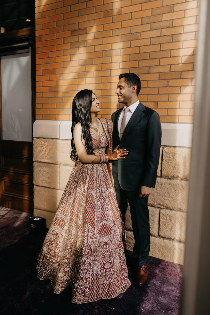 Bride and groom smiling at each other during wedding reception at Renaissance Depot Minneapolis, captured by Mycah Bain Photography, traditional wedding photographer.