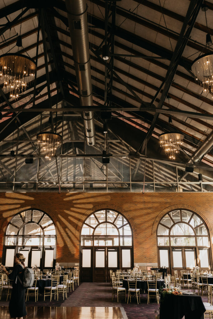 Renaissance Depot wedding reception hall with exposed beams, chandeliers, and dramatic architecture | Mycah Bain Photography.