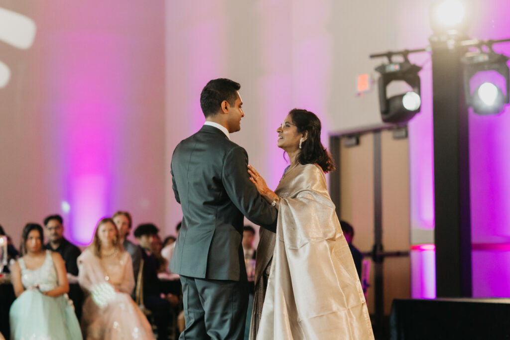 Groom shares a heartfelt dance with his mother under warm reception lighting at Renaissance Depot | Captured by Mycah Bain Photography.