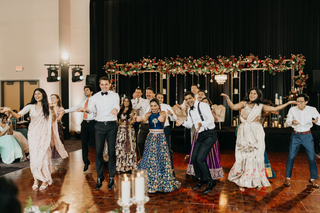 Large group of friends performing high-energy dance at Indian wedding reception in Minneapolis | Mycah Bain Photography.