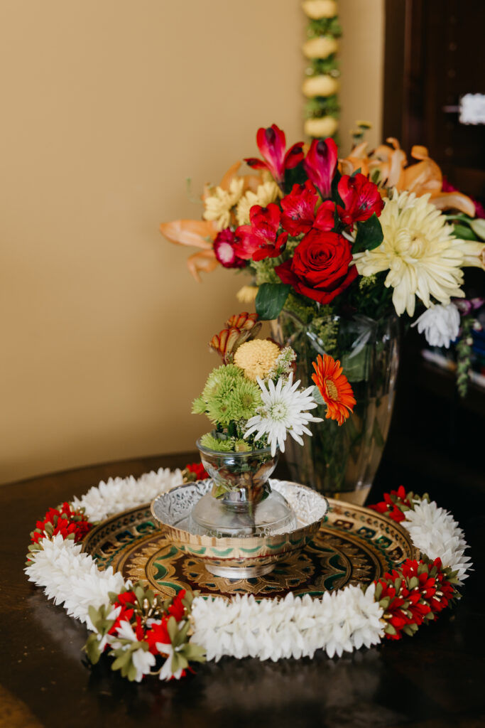 Traditional Var Pooja setup with floral garlands, silver tray, and sacred offerings at Indian wedding