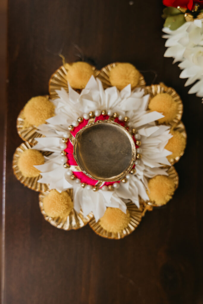 Decorative golden plate with white flowers and sacred diya lamp for Var Pooja ceremony