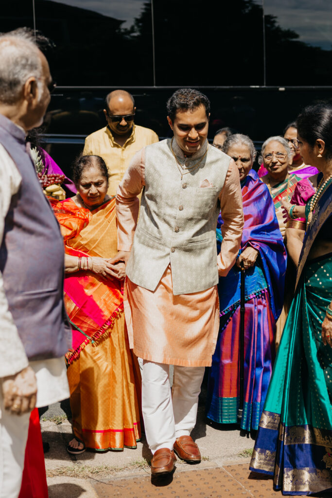 Groom Sanjay welcomed by family elders outside the home during Var Pooja morning ceremonies