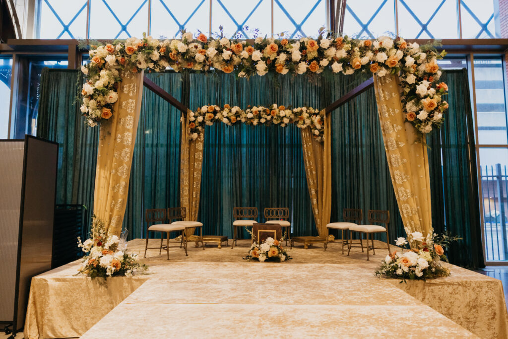 Luxurious Indian wedding mandap draped in emerald green fabric with floral garlands at Renaissance Depot