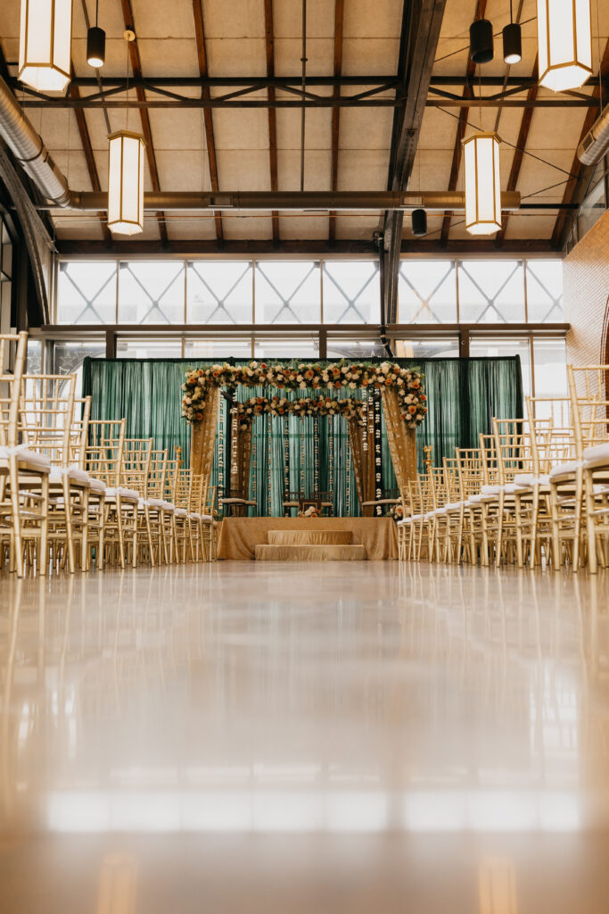 Elegant wedding ceremony aisle at Renaissance Depot Hotel with floral mandap decorated in gold and greenery