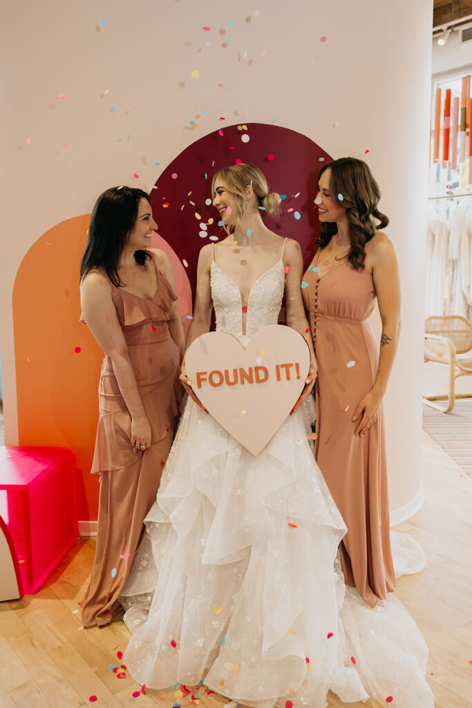 Bride and bridesmaids share a joyful confetti moment at Vow’d Weddings Minneapolis after saying yes to the dress.