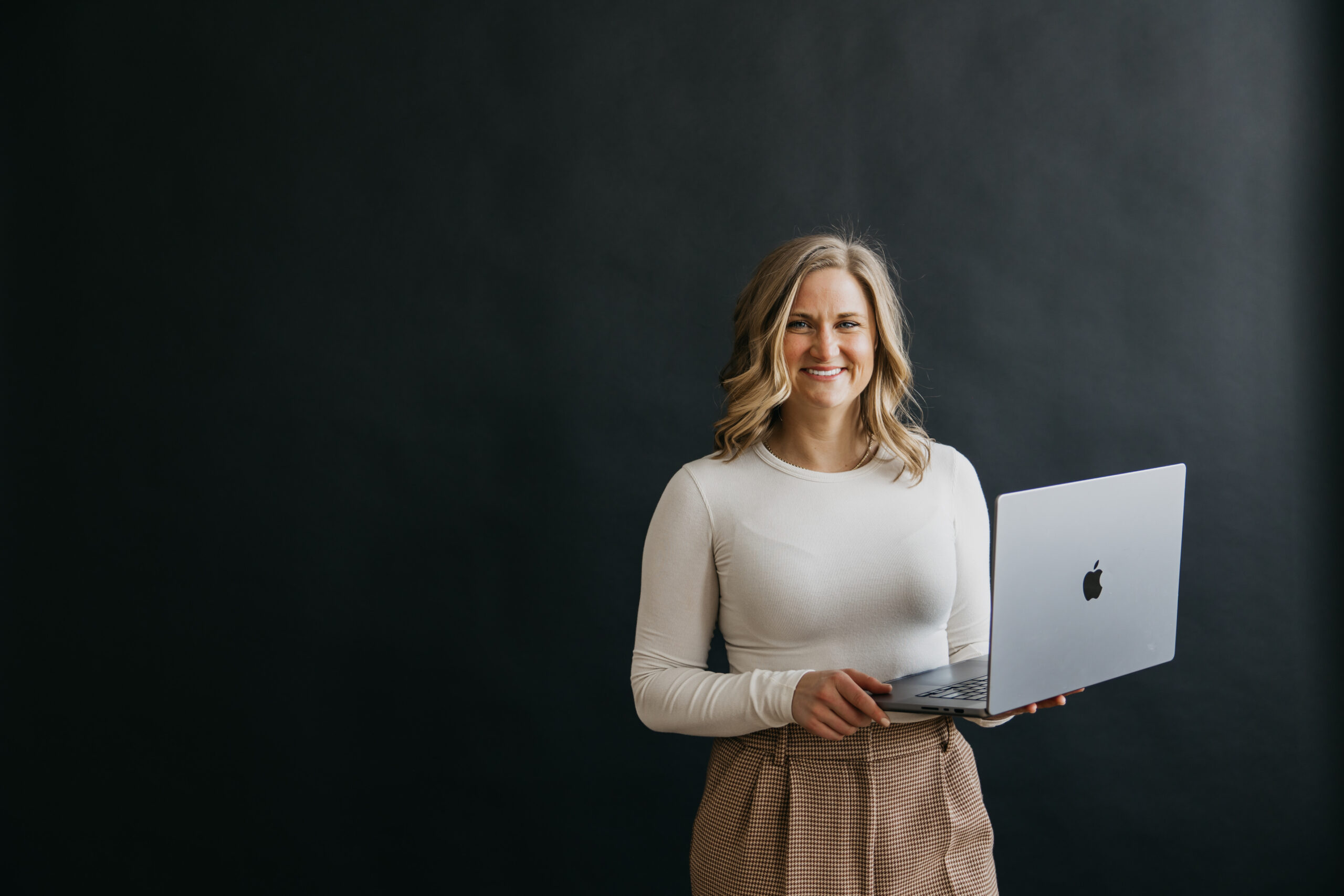 AI and business coach Callan Faulkner holding a laptop during her Minneapolis brand photoshoot with Mycah Bain Photography