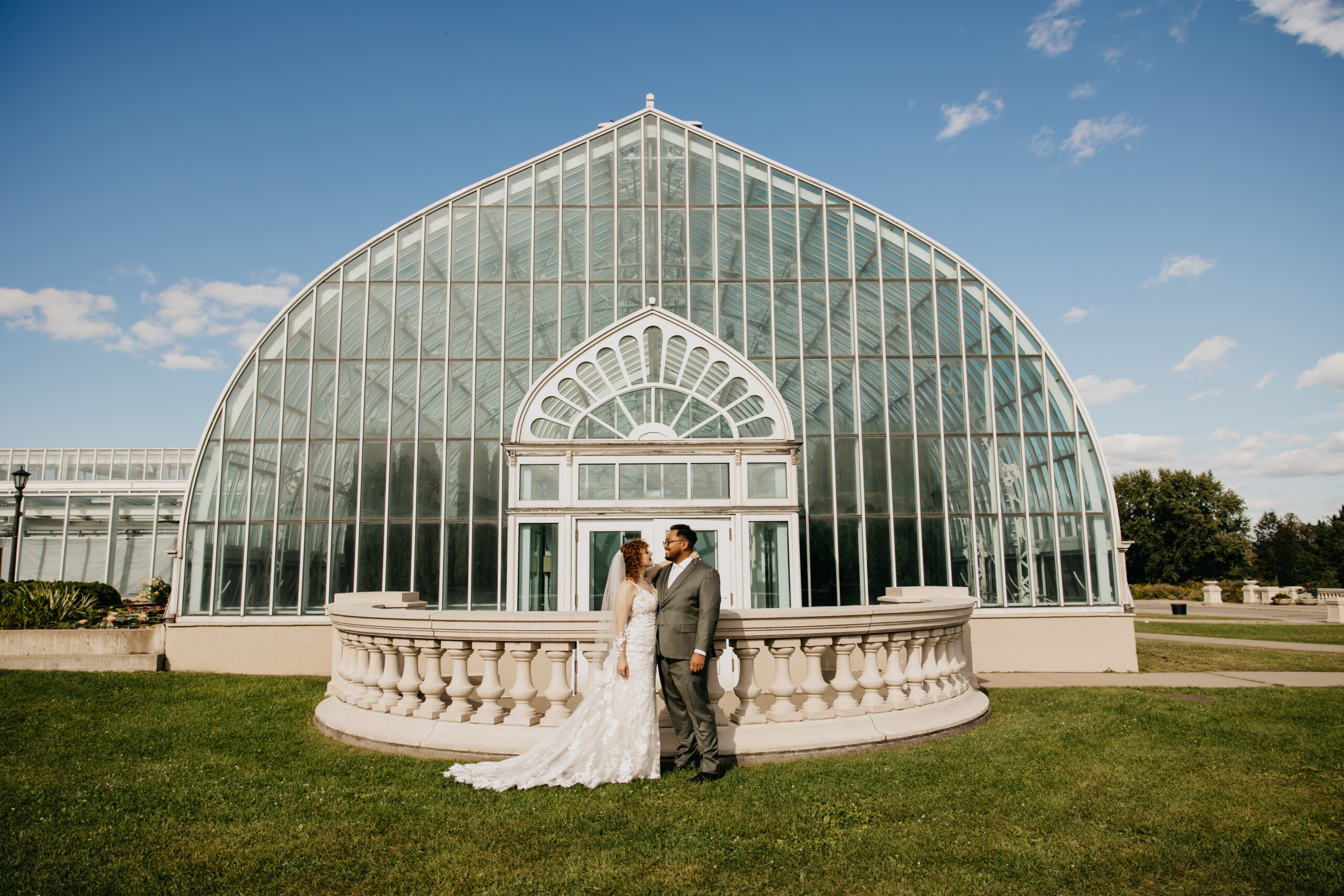 Bride and groom standing in front of the glass dome at Como Park Conservatory in Saint Paul, Minnesota.