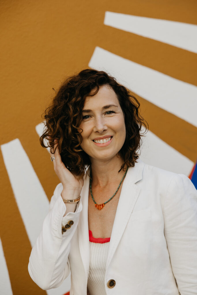 Anne Deanovic of Hot Mustard PR poses in front of a colorful mural near 50th & France during her brand photography session in Edina with Mycah Bain Photography.