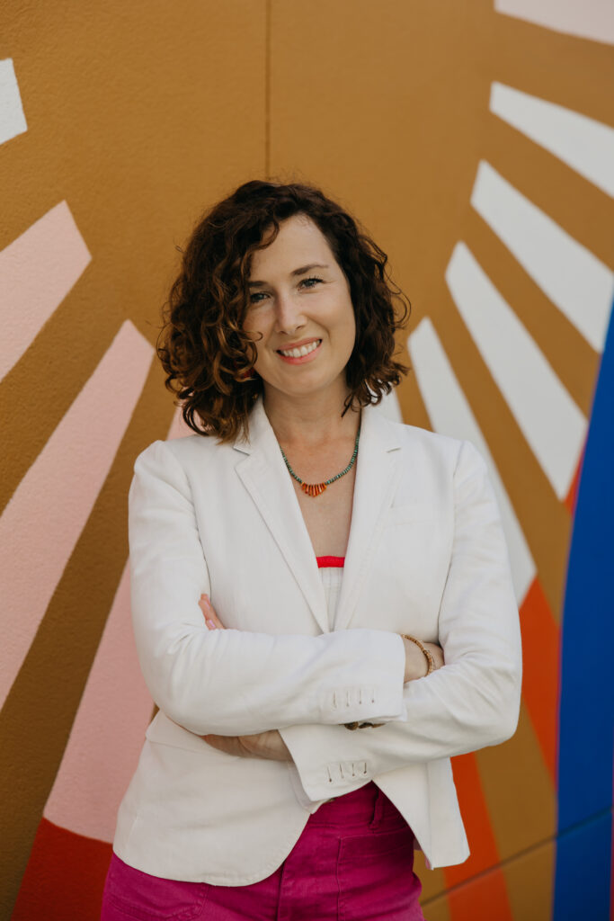 Anne Deanovic of Hot Mustard PR poses in front of a colorful mural near 50th & France during her brand photography session in Edina with Mycah Bain Photography.