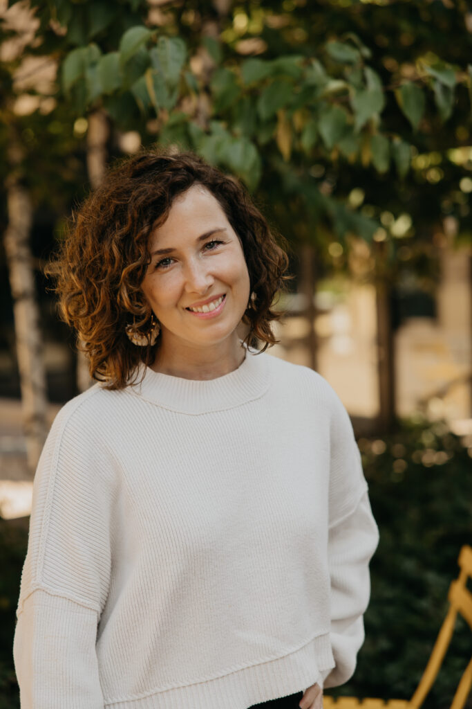 Anne Deanovic smiles in soft natural light during her Edina brand photoshoot, reflecting the warm, approachable side of her PR business.