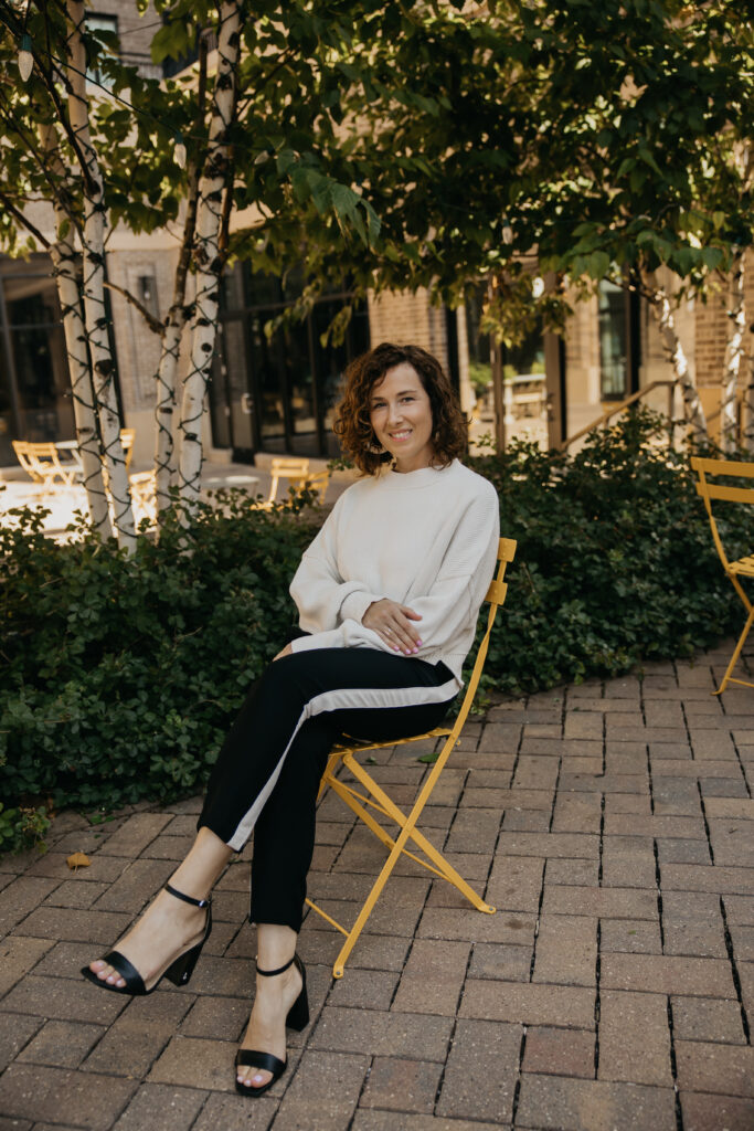Anne Deanovic smiles in soft natural light during her Edina brand photoshoot, reflecting the warm, approachable side of her PR business.