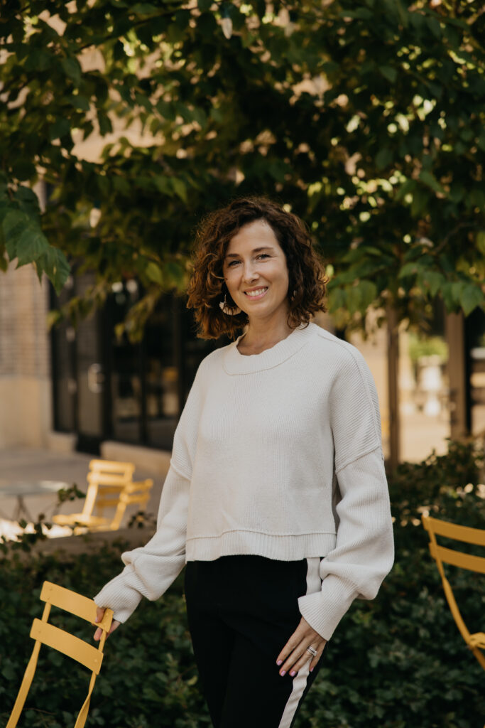 Anne Deanovic smiles in soft natural light during her Edina brand photoshoot, reflecting the warm, approachable side of her PR business.