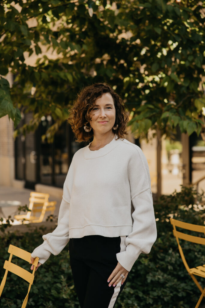 Anne Deanovic smiles in soft natural light during her Edina brand photoshoot, reflecting the warm, approachable side of her PR business.