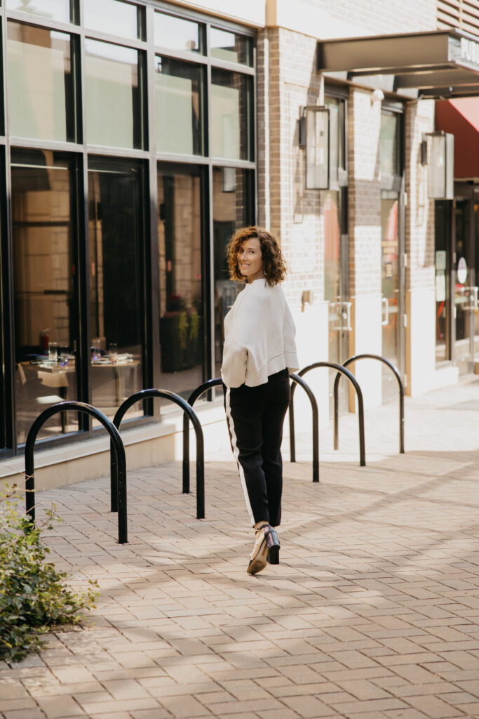 Anne Deanovic smiles in soft natural light during her Edina brand photoshoot, reflecting the warm, approachable side of her PR business.
