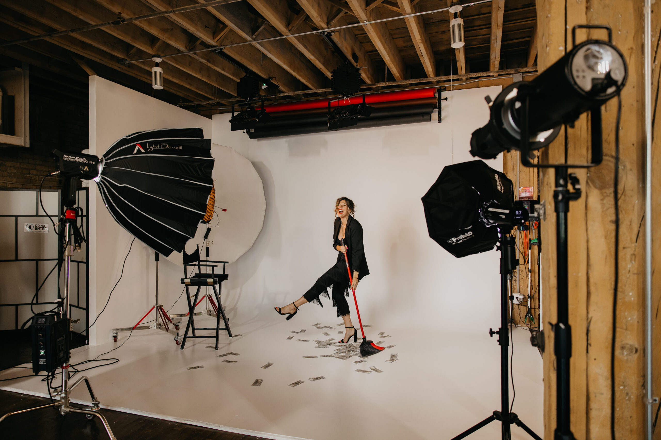 Behind-the-scenes look at Dr. Lauryn’s brand photoshoot with Minneapolis Luxury Brand Photographer Mycah Bain at Studio One, featuring creative lighting and playful money prop setup.