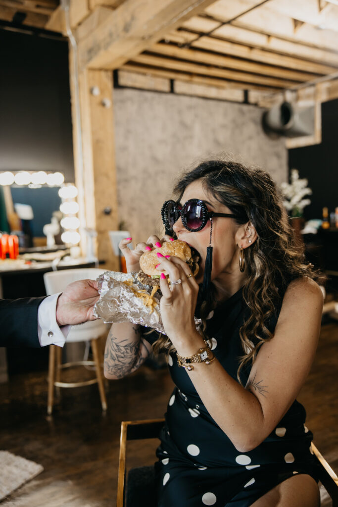 Candid photo of Dr. Lauryn laughing while eating fries and holding a Coke during her luxury brand session at Studio One Minneapolis.