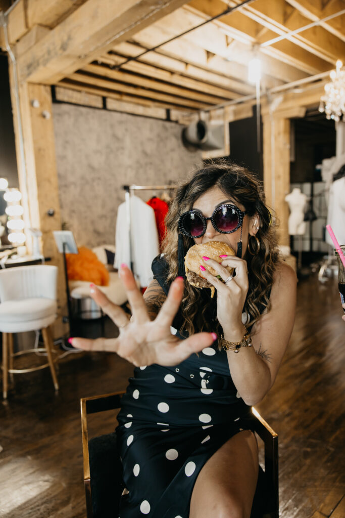 Candid photo of Dr. Lauryn laughing while eating fries and holding a Coke during her luxury brand session at Studio One Minneapolis.