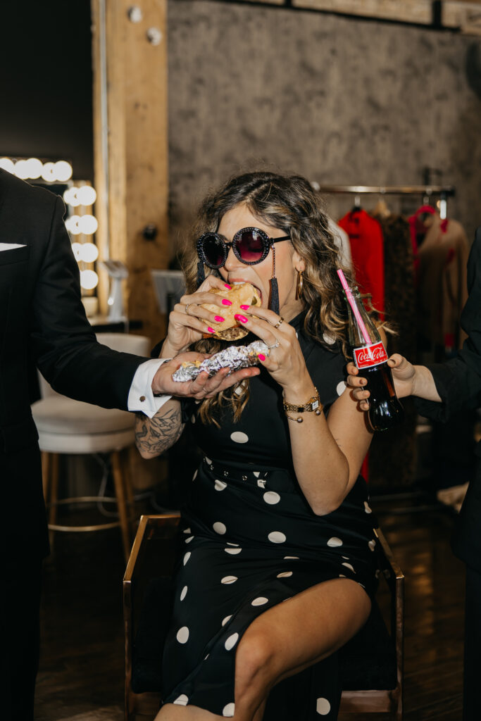 Candid photo of Dr. Lauryn laughing while eating fries and holding a Coke during her luxury brand session at Studio One Minneapolis.