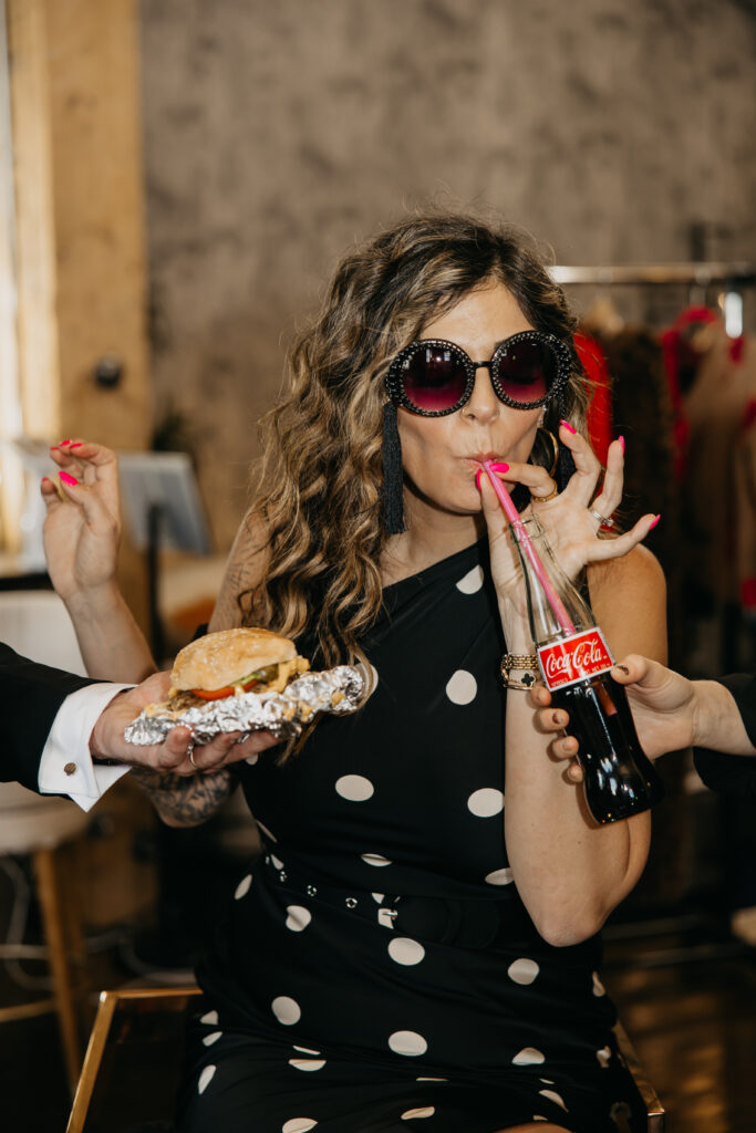 Candid photo of Dr. Lauryn laughing while eating fries and holding a Coke during her luxury brand session at Studio One Minneapolis.