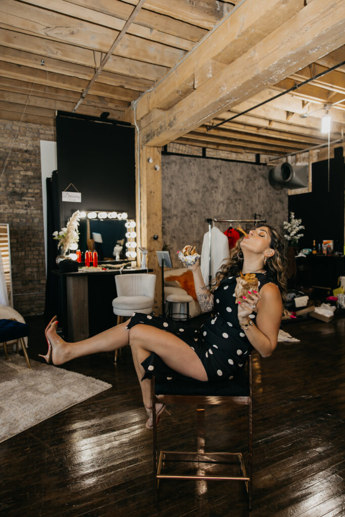 Candid photo of Dr. Lauryn laughing while eating fries and holding a Coke during her luxury brand session at Studio One Minneapolis.