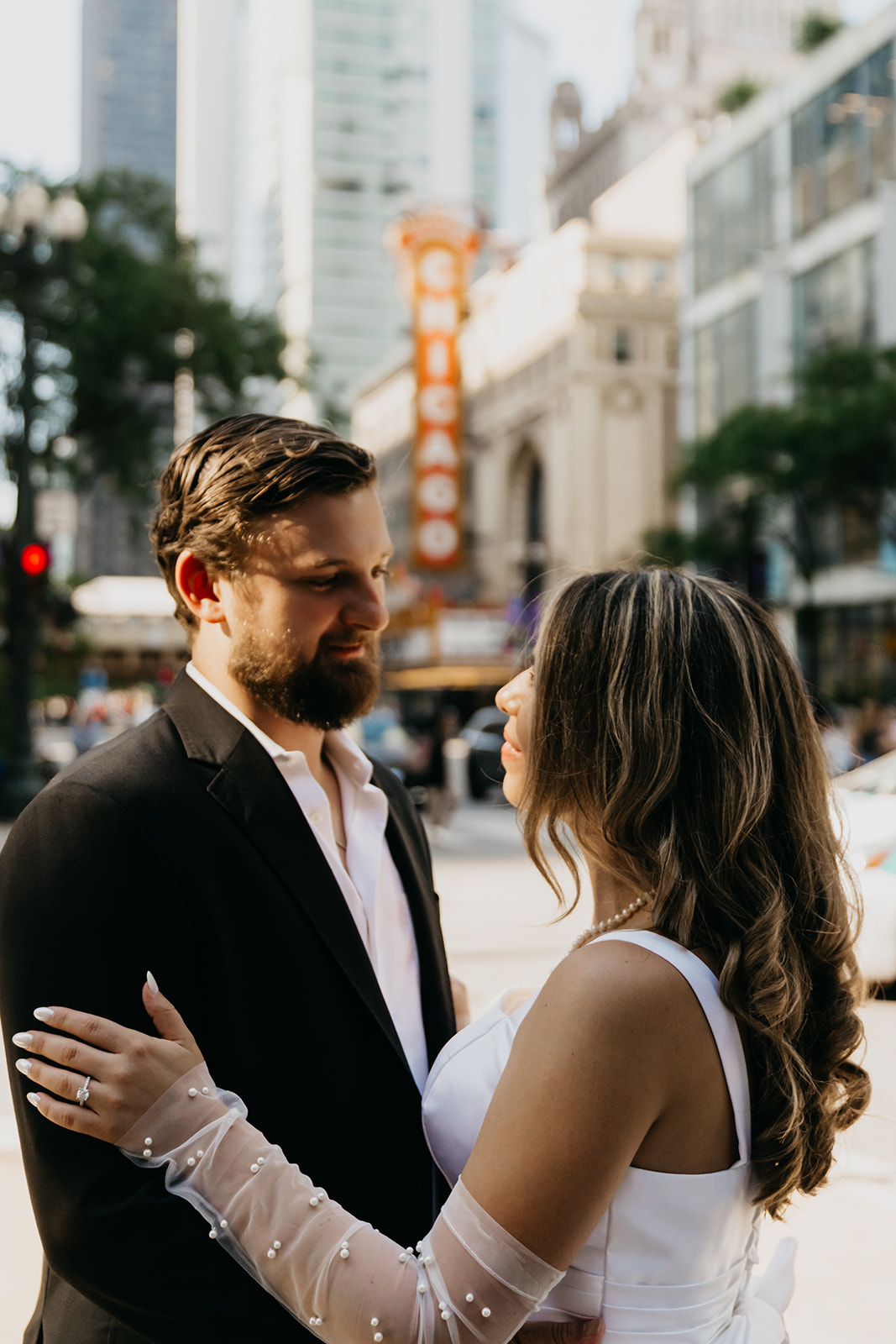 Lauren and Mike sharing a quiet, romantic moment in downtown Chicago with the iconic Chicago Theatre sign blurred in the background.