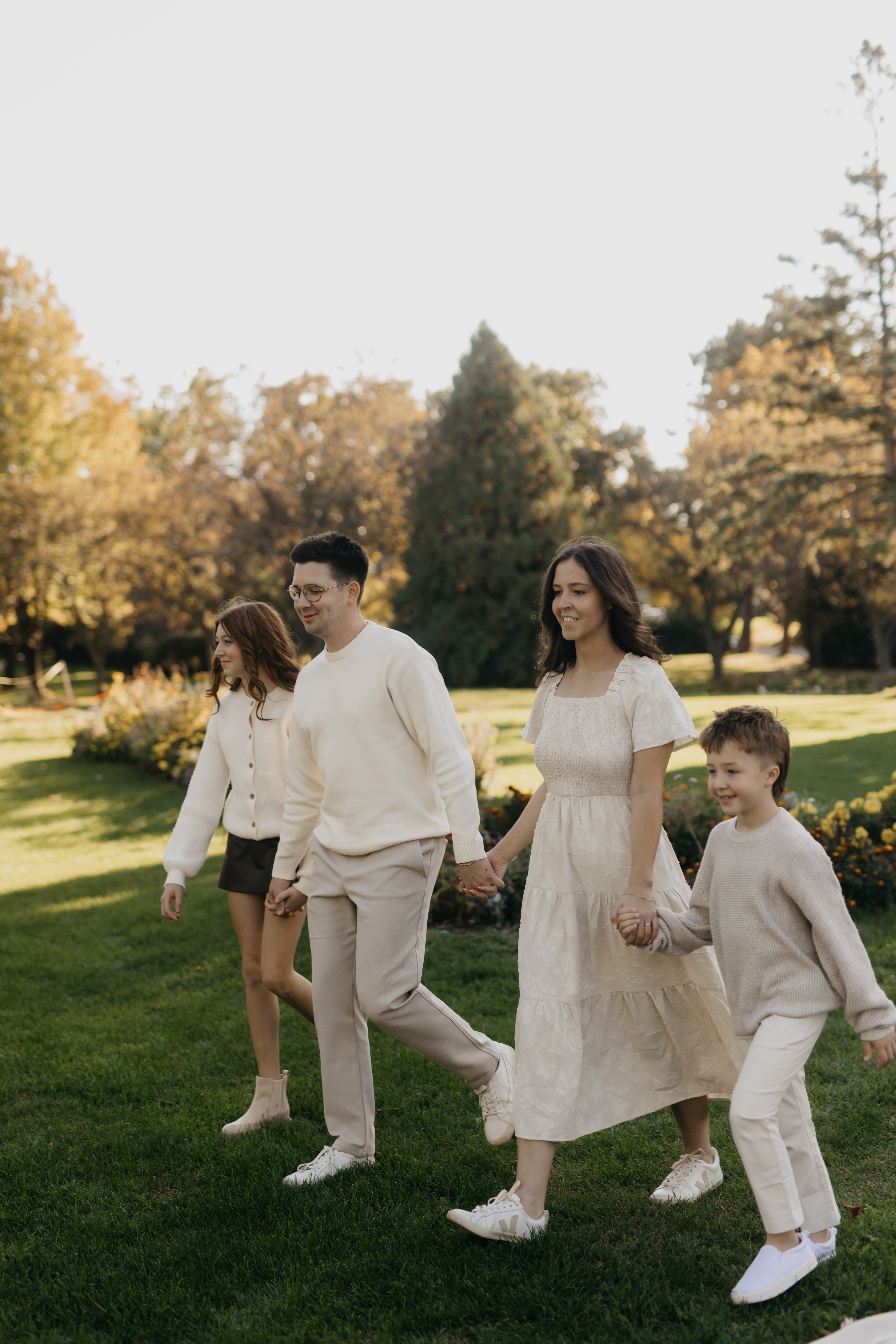 Fall family photos in Minneapolis — the Firminger family walking hand in hand through golden autumn trees with Mycah Bain Photography.